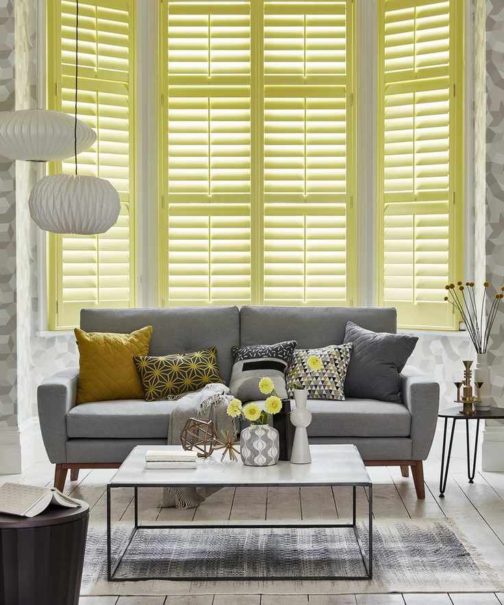 A living room adorned with yellow shutters and a gray sofa
