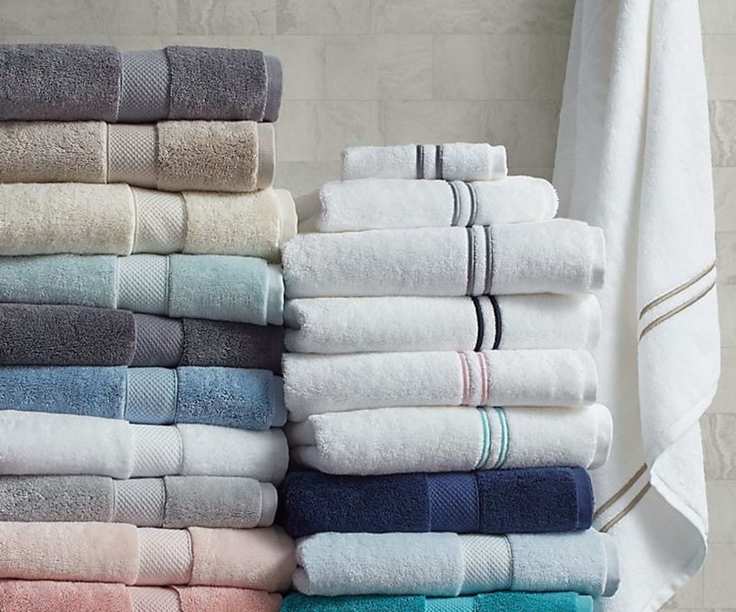 A stack of Wamsutta bath towels in a bathroom.