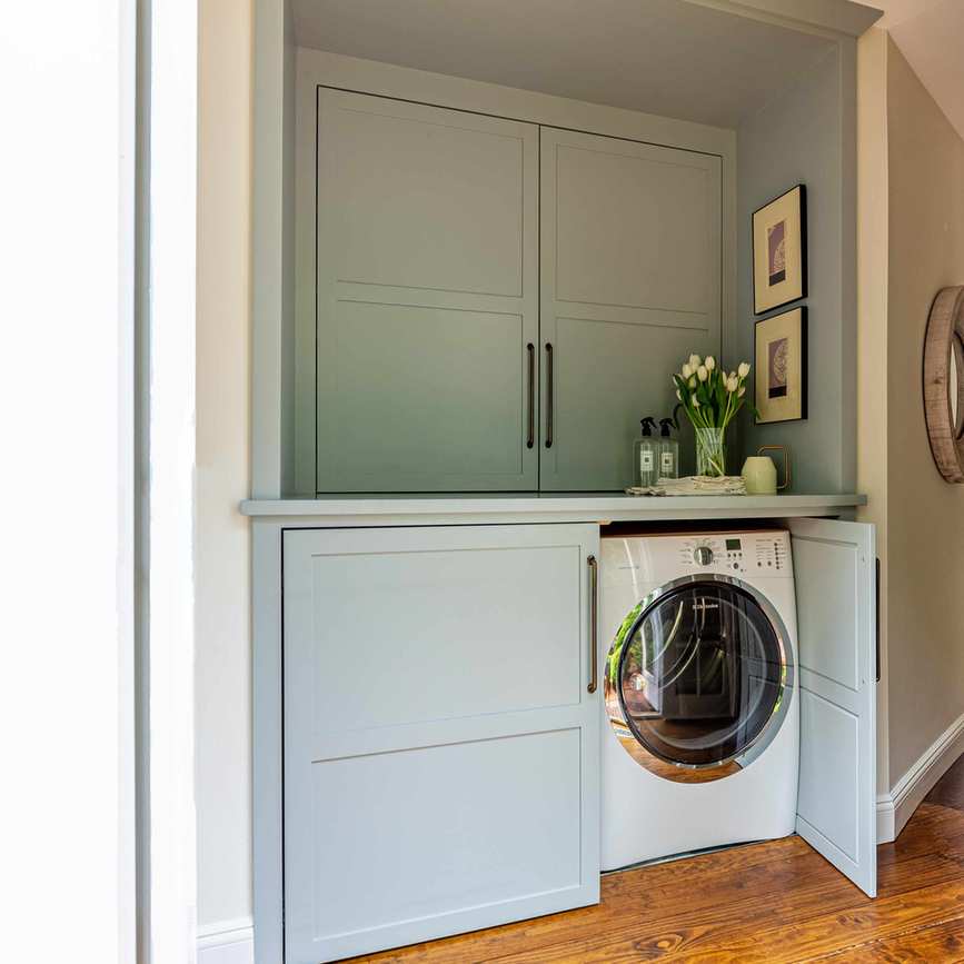 Laundry space hidden behind cabinets
