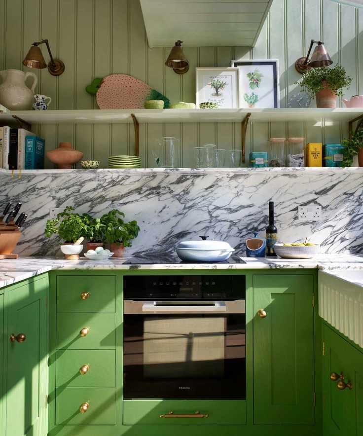 A green kitchen with oversized brass hardware