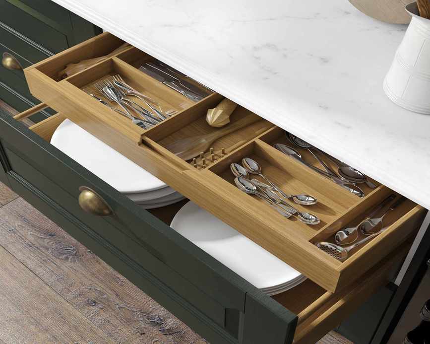 green kitchen drawer open to show cutlery neatly organized in dividers