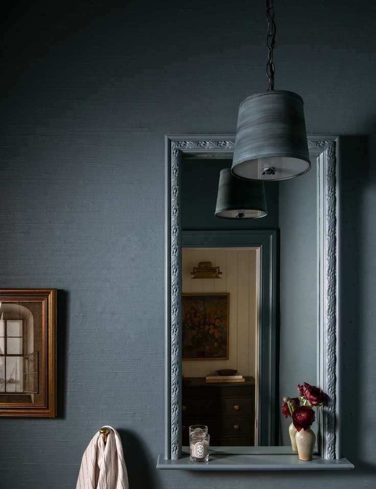 Bathroom area featuring blue-gray tones with pendant lighting and artwork