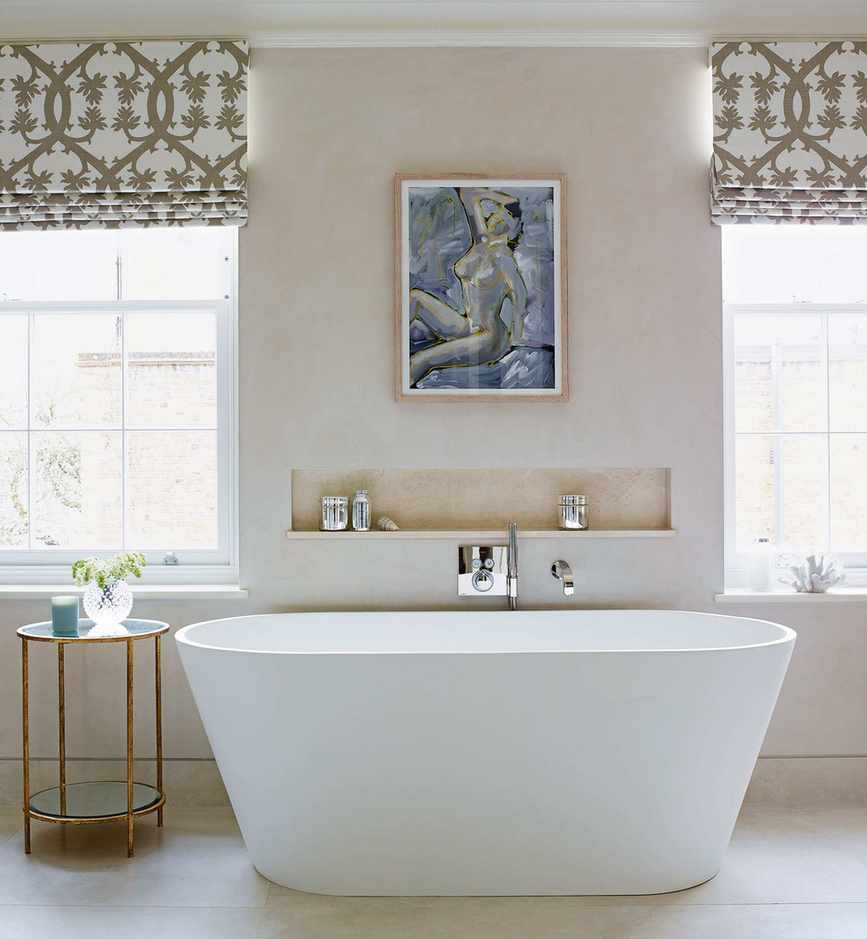 A cream bathroom with a rolltop bath and bathroom shelf in a niche