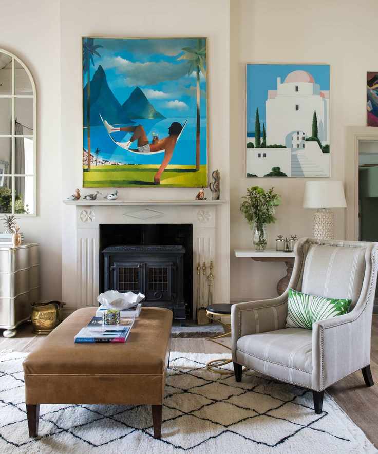 A modern living room with a wood-burning stove and decorative art on the walls.