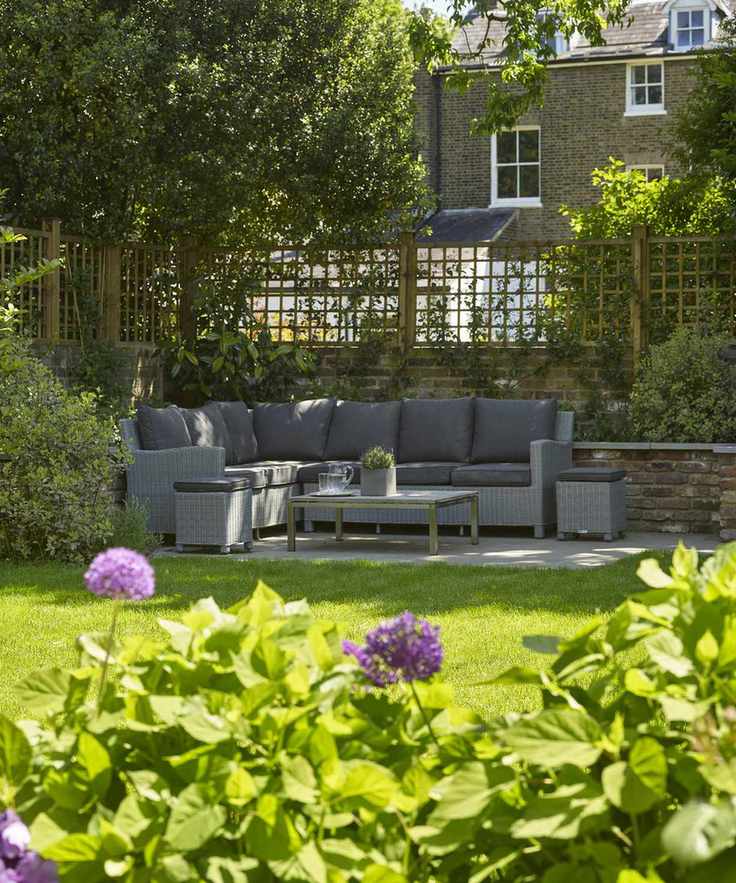 Patio seating area at the rear of a garden with a lawn in front