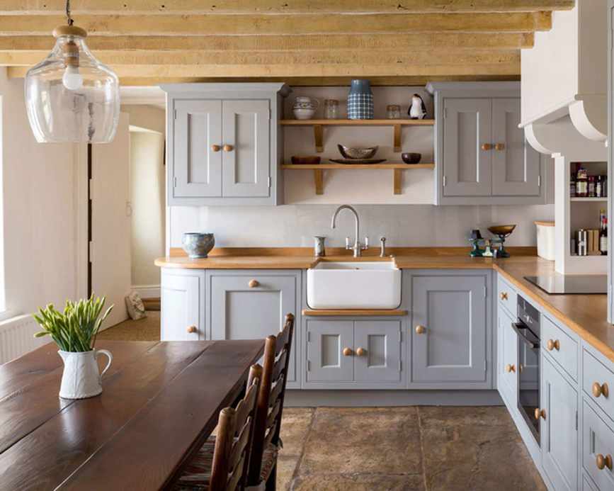 Traditional country kitchen diner with grey cabinetry, wooden worktops and dark wood table