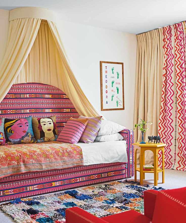 Tall daybed with a cream canopy and colorful decor