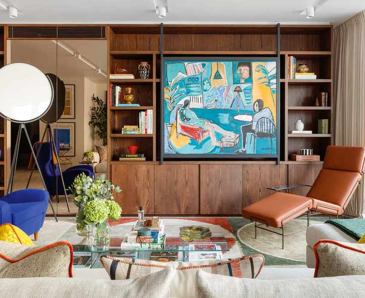 Modern living room with bespoke, dark wood media cabinet, painting covering TV, leather chaise, glass coffee table