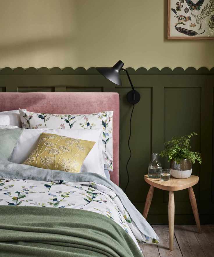 Bedroom with dark green paneling and floral bedding