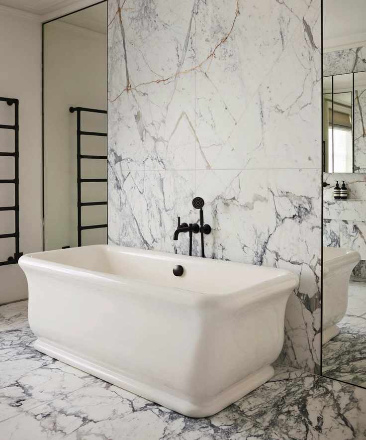 a modern bathroom with extra large marble tiles, freestanding bathtub and mirrored wall panels