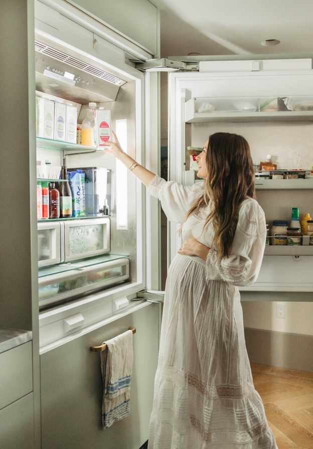 Pregnant woman looking into refrigerator