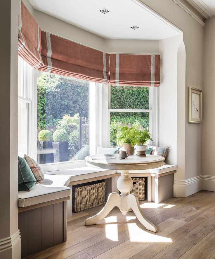 Bay window with built in window seat on wooden flooring.