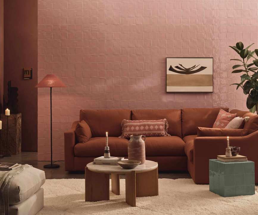 A living room with walls covered in square earth-tone tiles