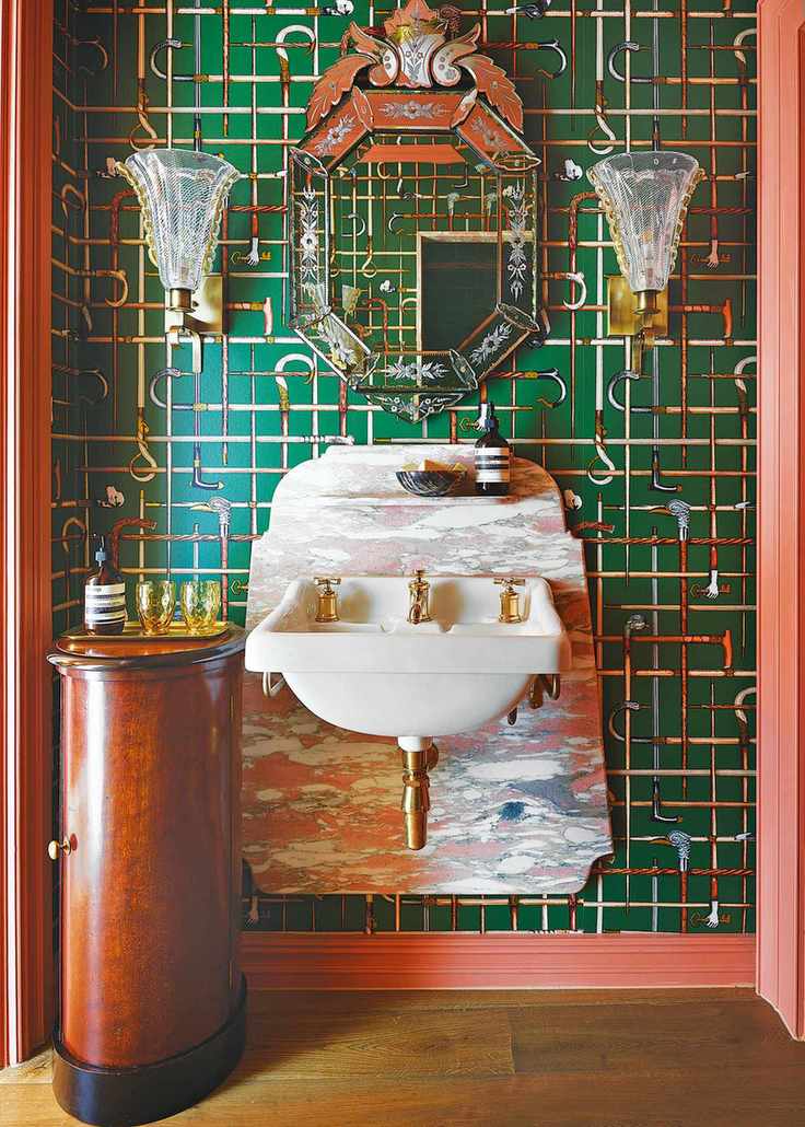 Colorful powder room with bold green wallpaper and gold accents