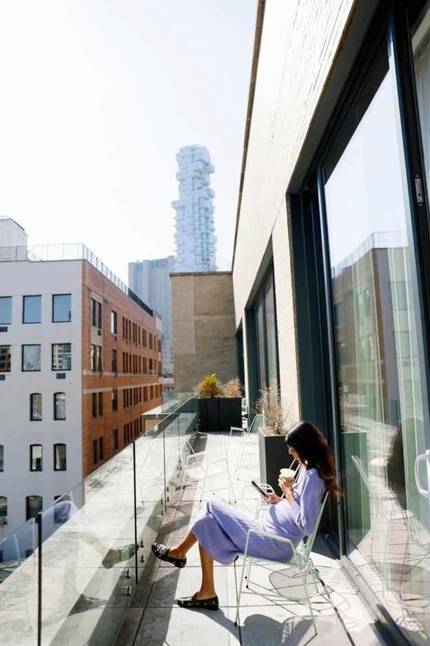 Woman enjoying a smoothie on a balcony