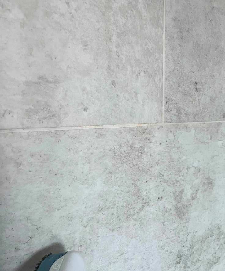 Steam cleaning white grout in grey shower tiles 