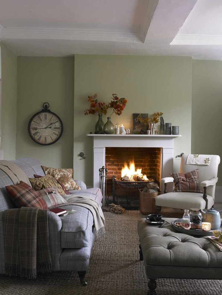 Green living room with brick open fireplace and gray check sofa