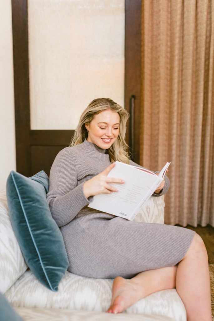Iskra Lawrence reading on couch.