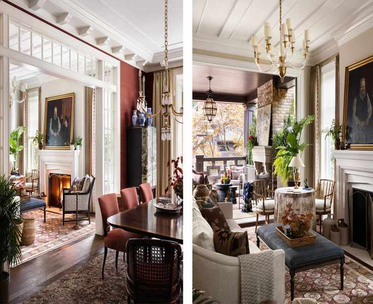a red grasscloth lined dining room with traditional tudor style millwork and molding, a dark wooden table, chandelier, vintage rug and a view through to the living room with a fireplace
