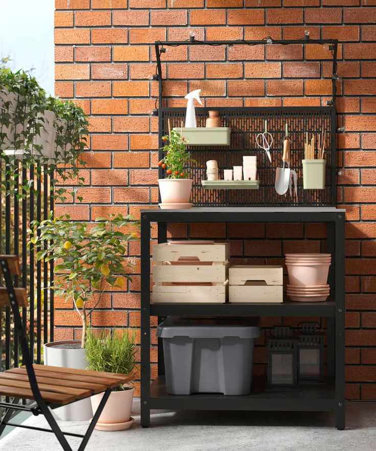 Black steel outdoor kitchen with gardening supplies and pots