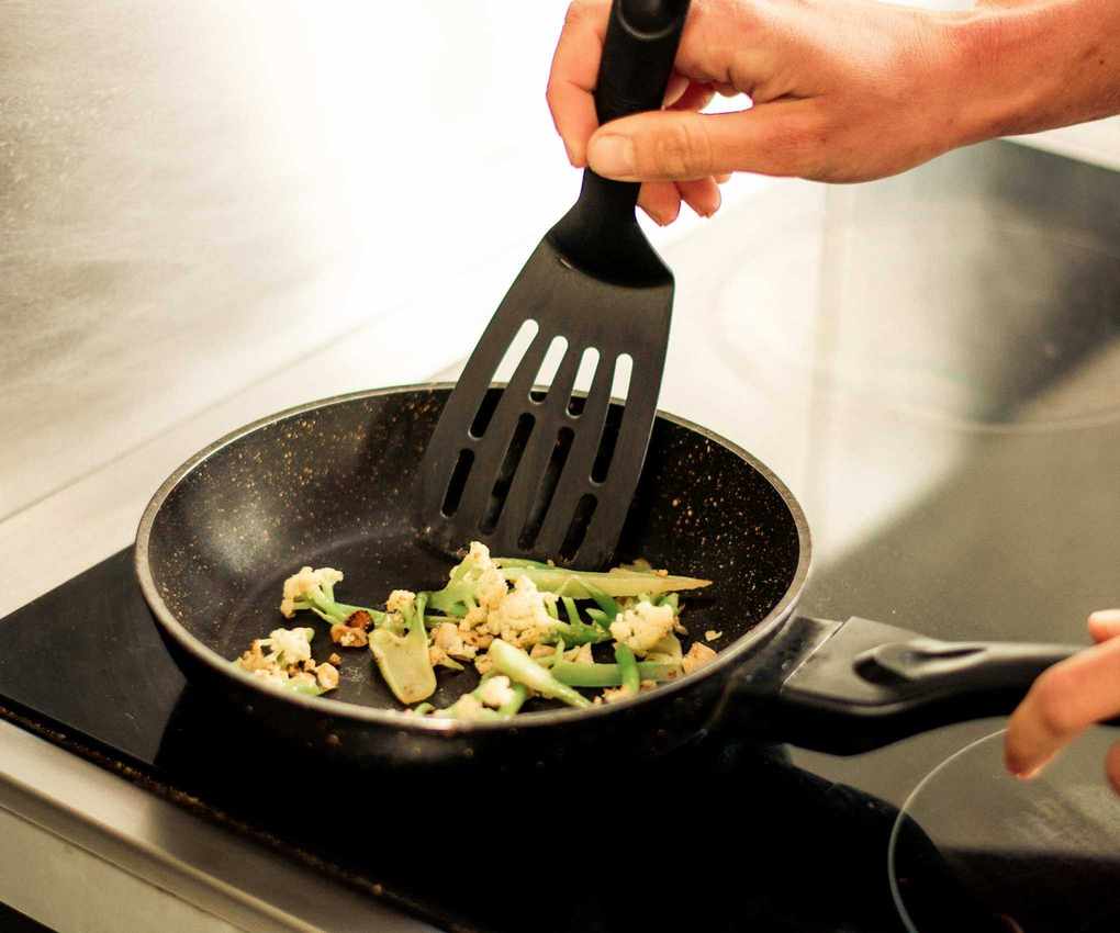 A black plastic spatula in a frying pan