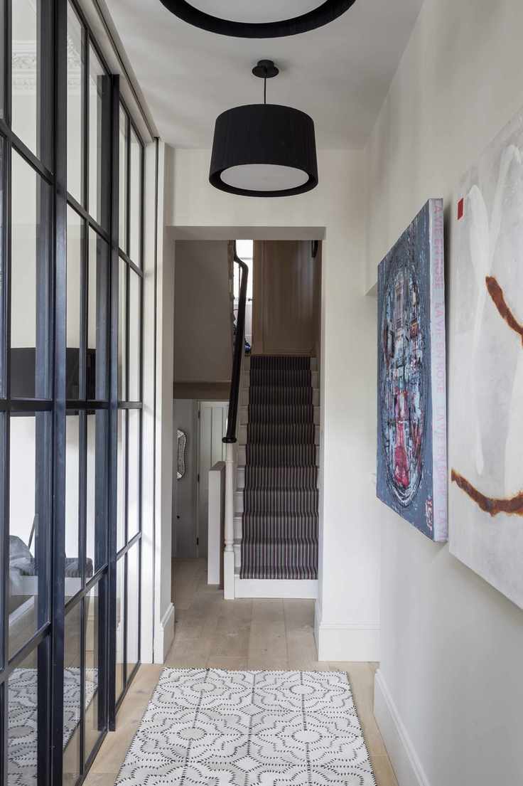 Neutral hallway with industrial divider on one side and view up staircase