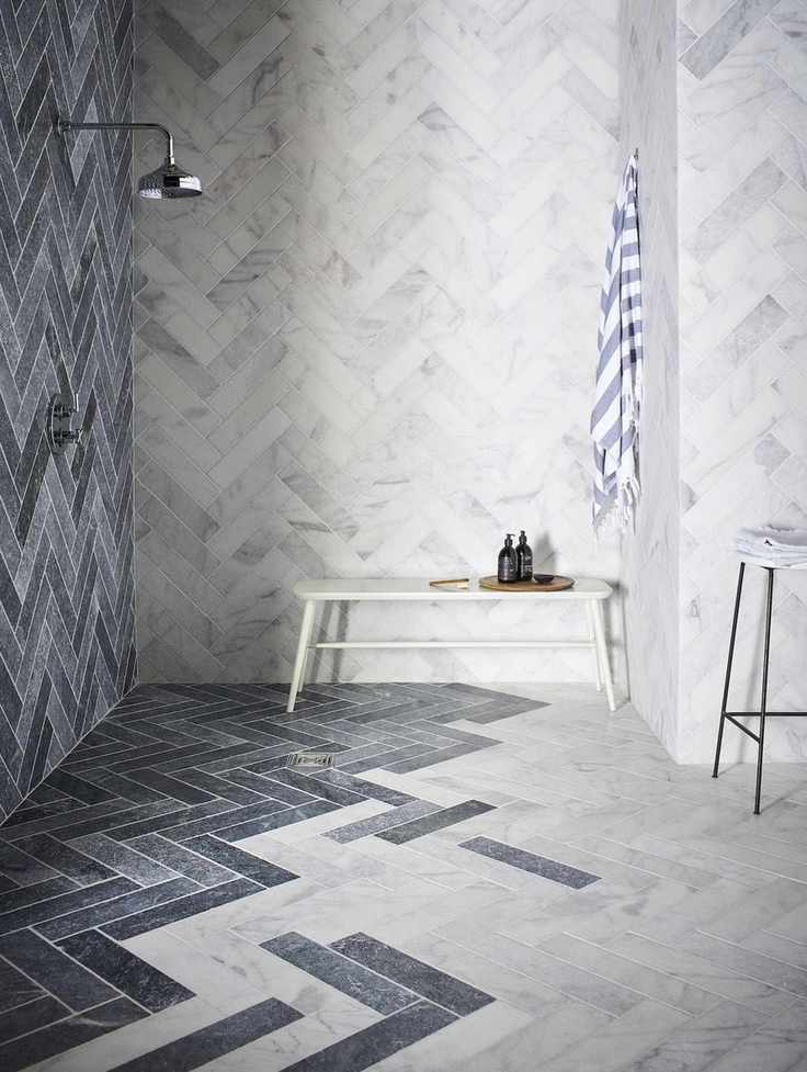 bathroom with marble floor and walls, chevron pattern, shower, shower bench