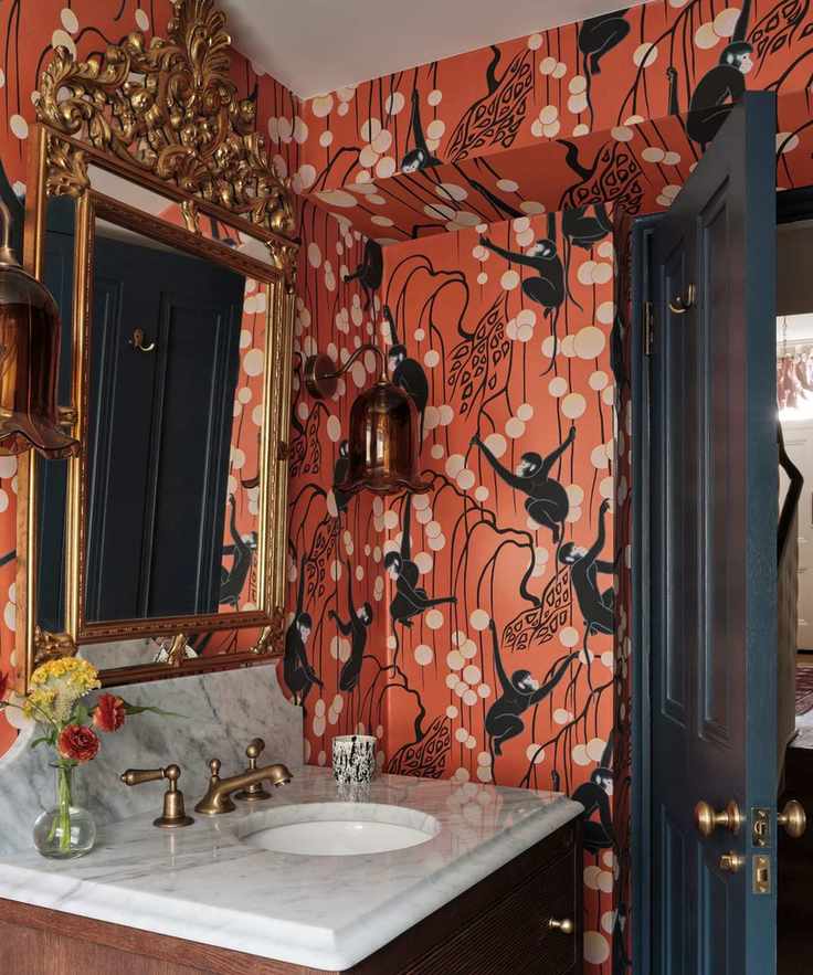 A small guest bathroom with red patterned wallpaper