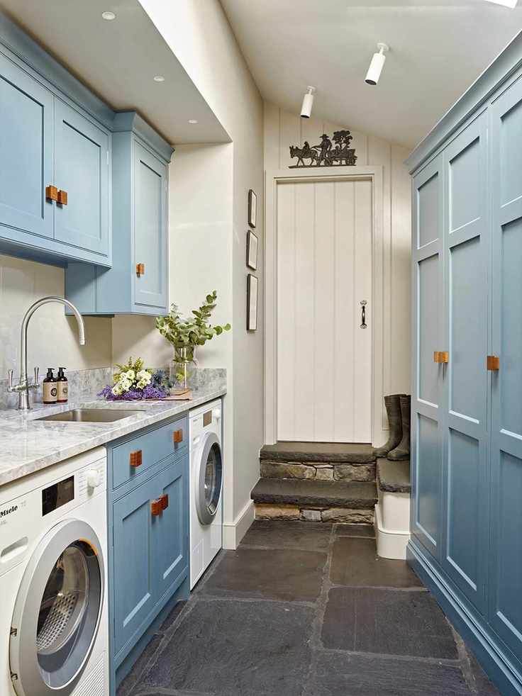 Utility room with blue cabinets and built-in washing machine