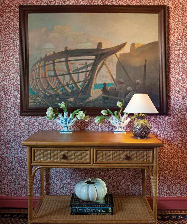 Hallway featuring red and white floral wallpaper, wooden console table, and decorative elements