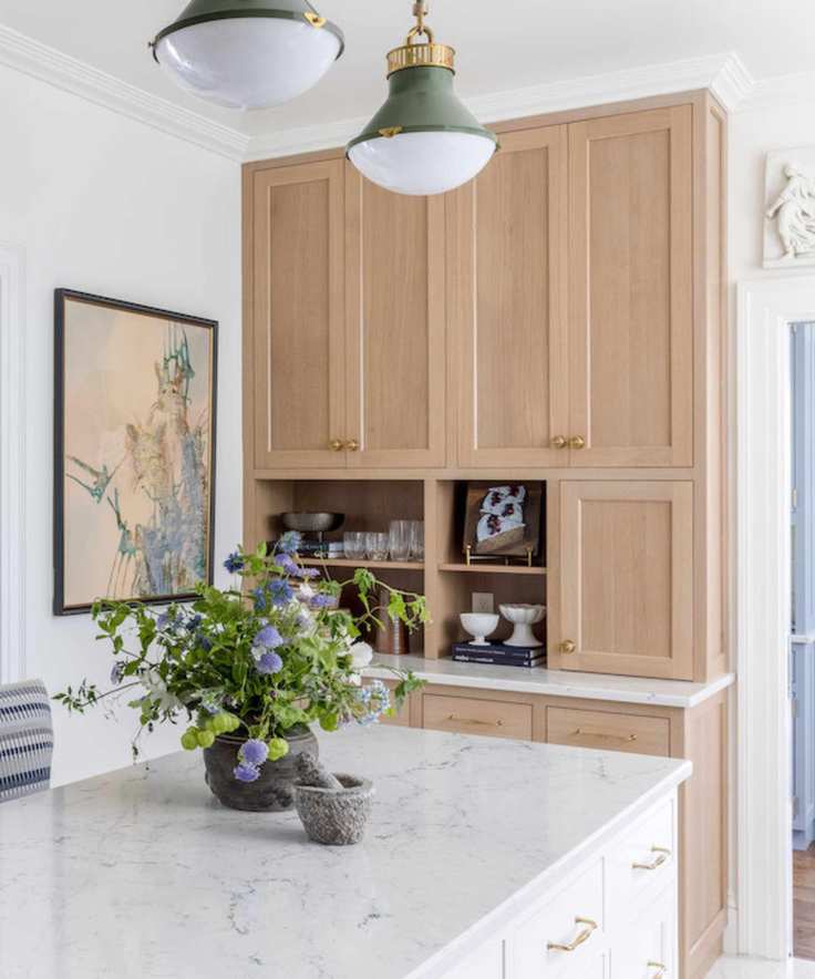 A kitchen with wooden cabinets and a marble countertop.
