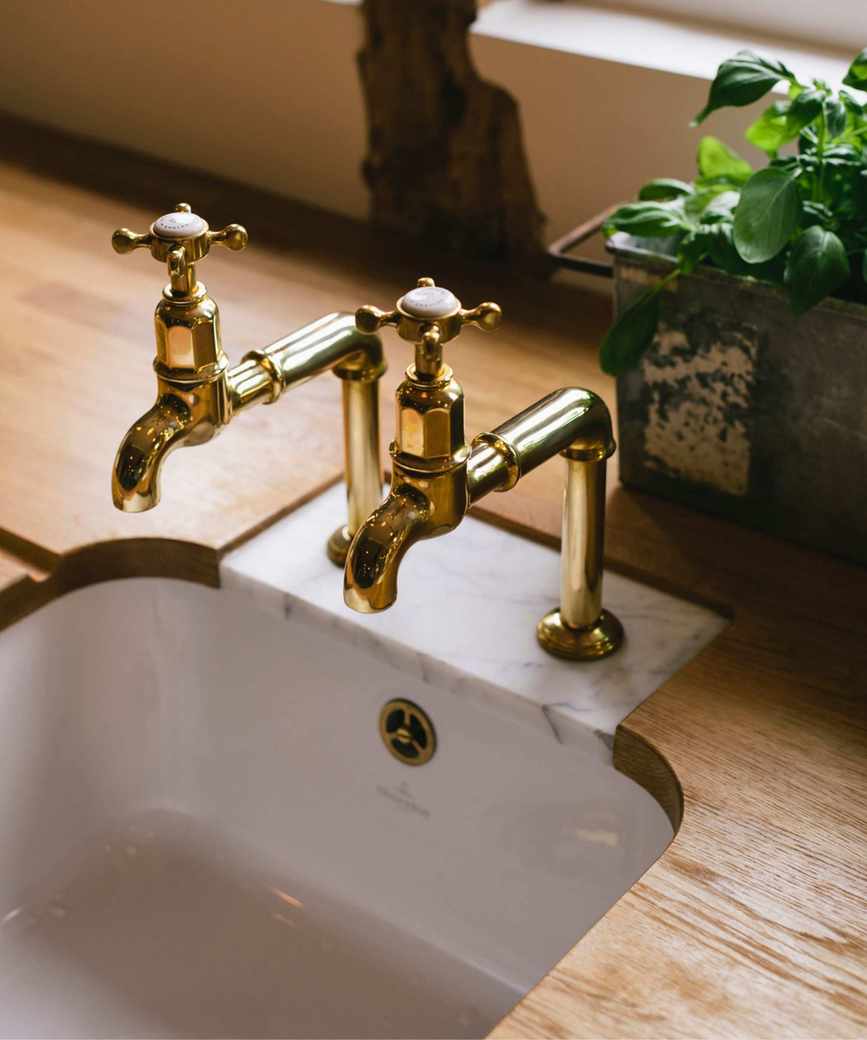 vintage kitchen taps on a wooden countertop with a marble inset
