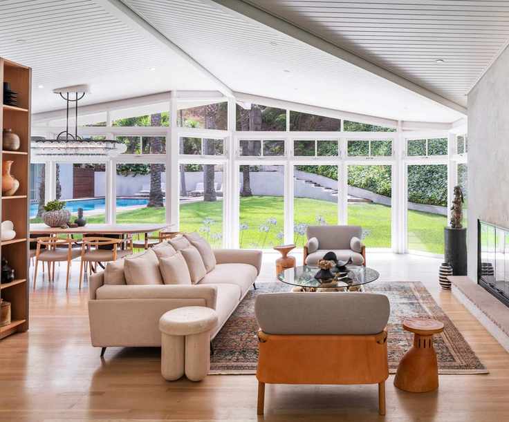 Open concept living space with neutral sofa and chair and dining space