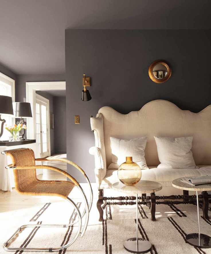 A stylish living room with a white couch and rich black walls.