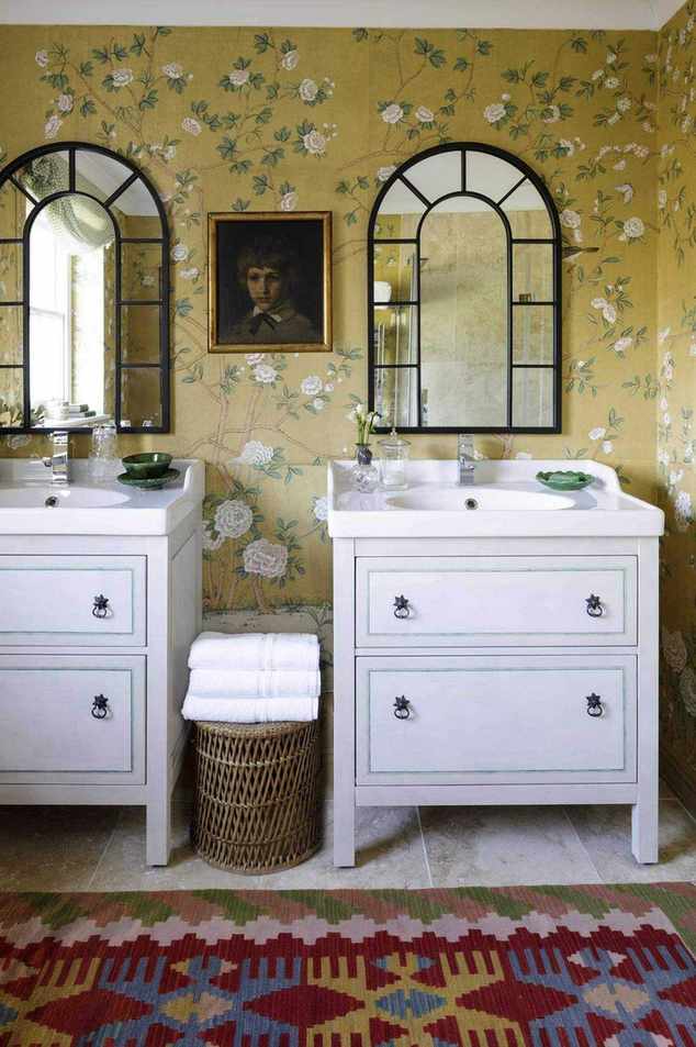 bathroom with yellow floral wallpaper, double vanities, colourful rug