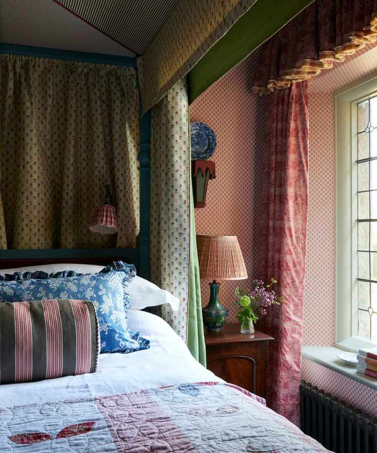 Vintage bedroom with canopy and quilt on bed and floral curtains