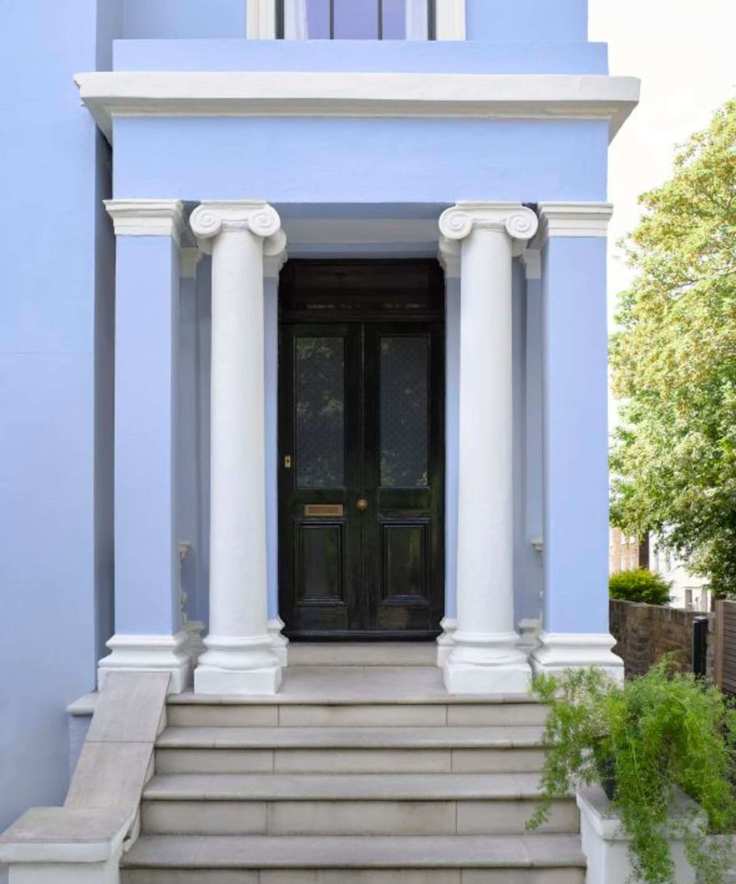 home exterior painted pastel blue with black front door