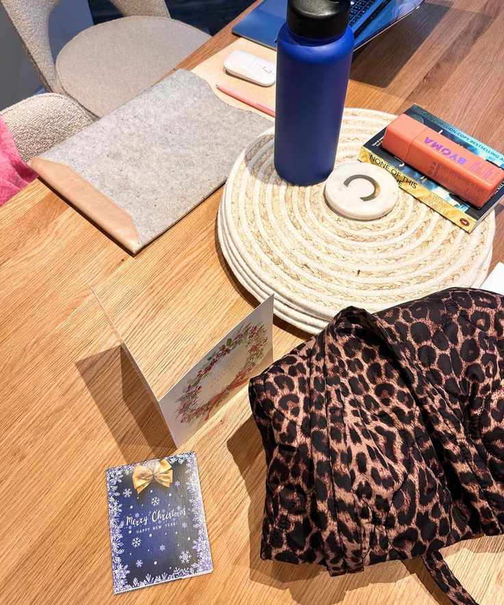 Messy dining room with cards, a bag and a book laid on top