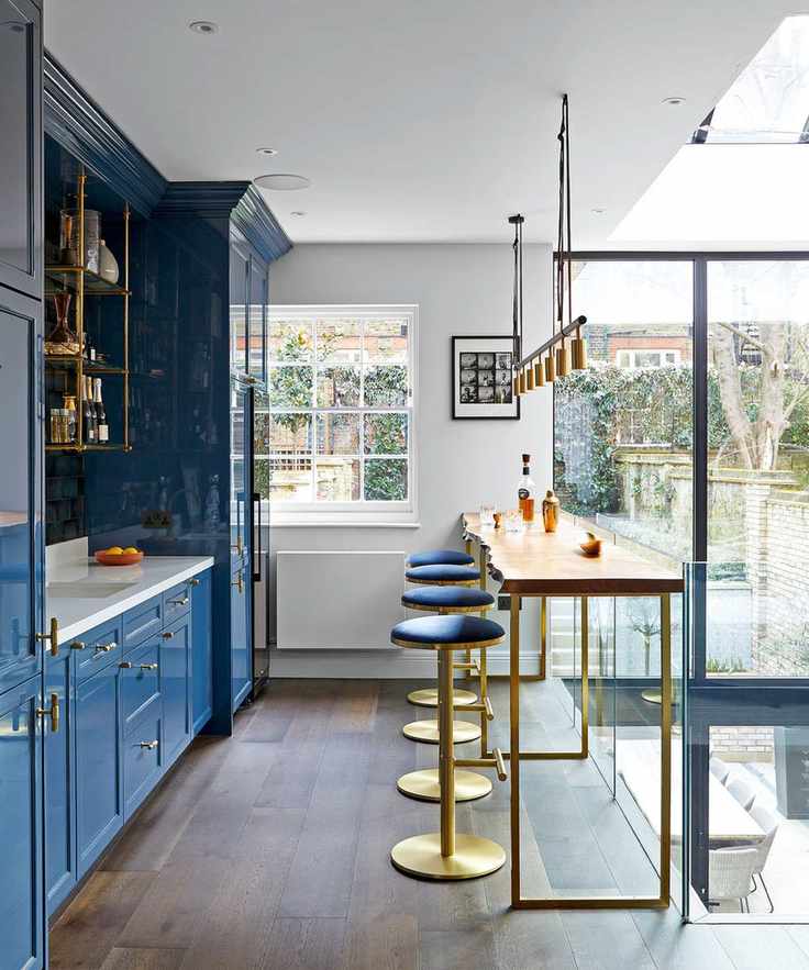 Mezzanine kitchen with blue cabinets and dark wooden floor
