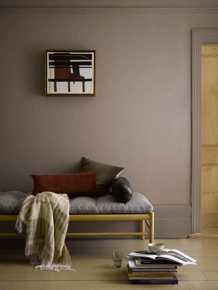 Living room with upholstered bench and chocolate colored walls, baseboards and trim