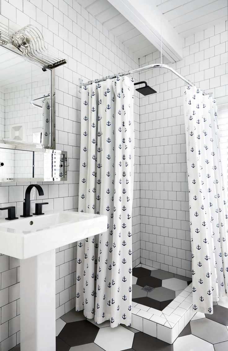 white tiled bathroom with anchor shower curtain, black and white floor tiles