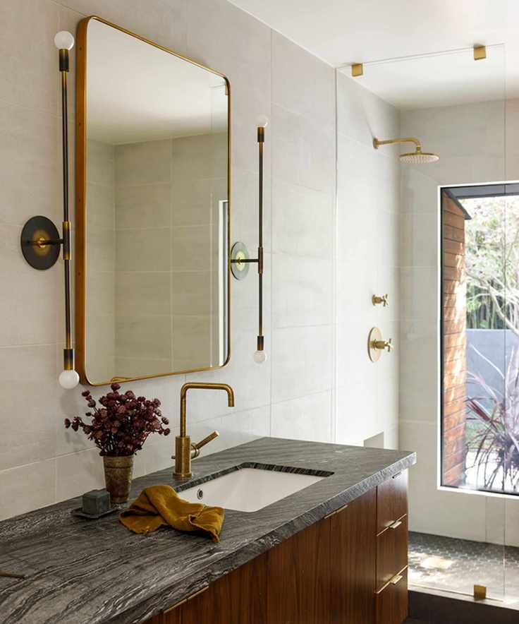 Midcentury bathroom with a large mirror above the sink