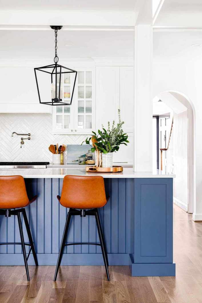 Kitchen featuring a blue island and leather barstools
