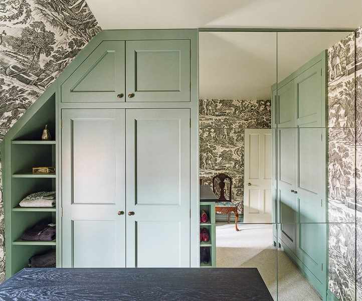 Small bedroom storage solutions illustrated by a built-in mint green wardrobe.