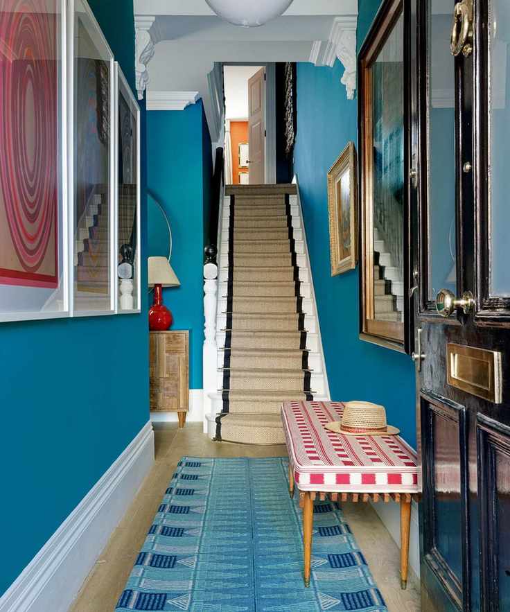 Blue entryway with red and white bench and red artwork