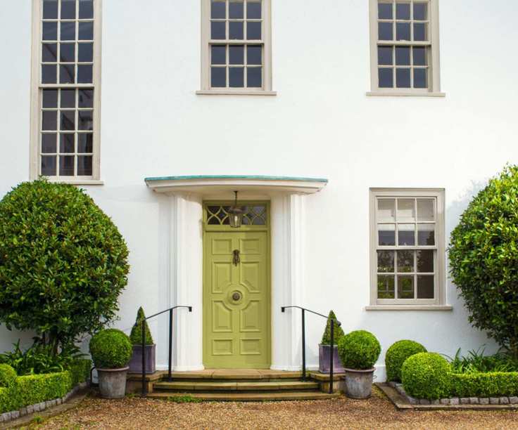 A white home exterior with lime green front door.