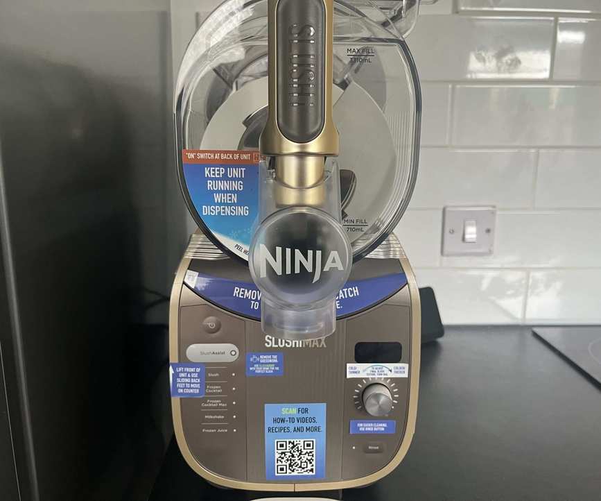 The gold and grey Ninja Slushi Max on a black kitchen countertop.