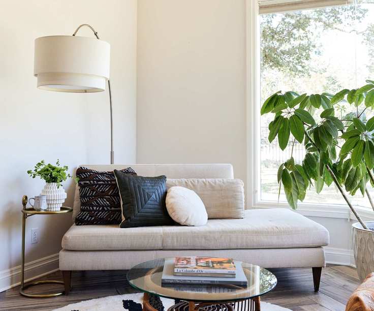 bedroom with white walls and white chaise longue and big plants