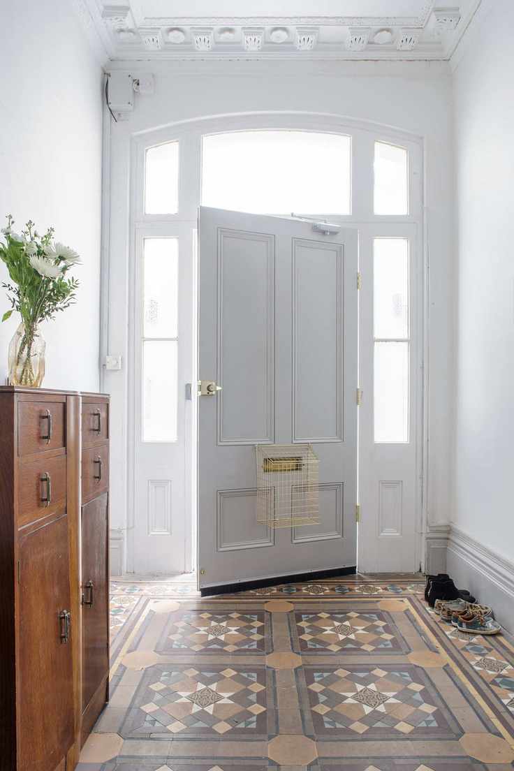 White hallway walls, tiled flooring with wood cabinet