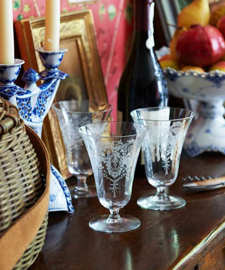 Thanksgiving detailed glassware on mahogany side board in room with red patterned wallpaper